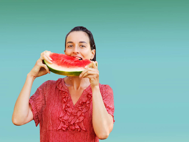 Fröhliche Frau mit einem Stück aufgeschnittener Wassermelone auf buntem Hintergrund. Sommerkonzept - Foto, Bild