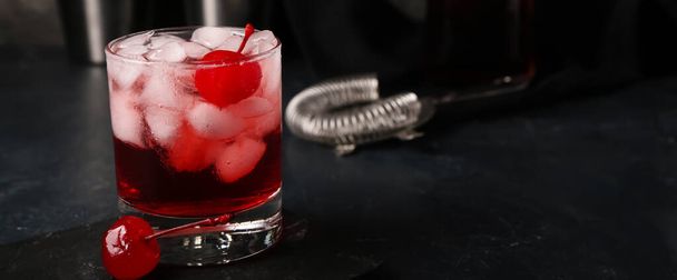 Glass of tasty Manhattan cocktail on dark background with space for text - Foto, afbeelding