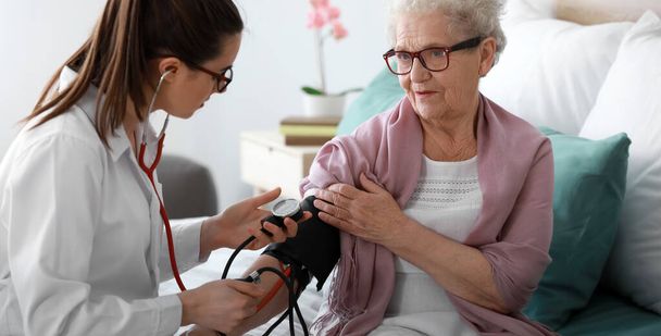 Arzt untersucht Seniorin in Pflegeheim - Foto, Bild