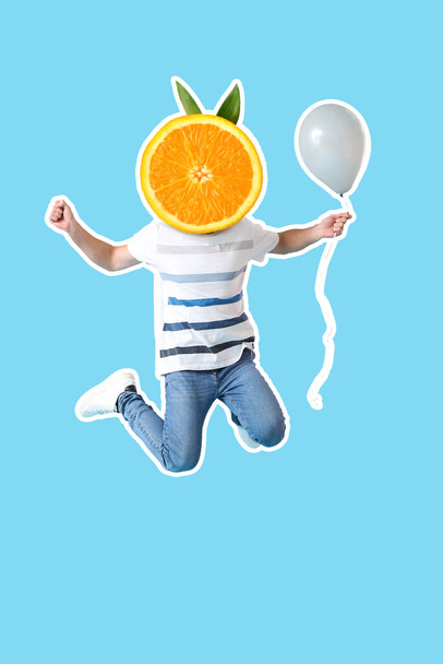 Портрет прыгающего молодого человека со спелым оранжевым вместо головы и воздушным шаром на светло-голубом фоне - Фото, изображение