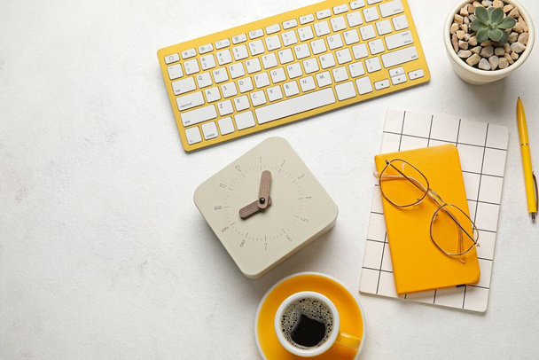 PC toetsenbord, notebooks, klok, bril en kopje koffie op lichte achtergrond - Foto, afbeelding