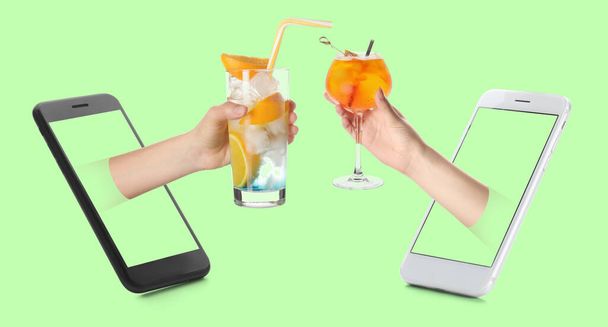 Smartphone e mani con gustosi cocktail freddi su sfondo verde - Foto, immagini