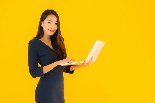 Muotokuva kaunis nuori aasialainen nainen kannettavan tietokoneen tai tietokoneen keltainen eristetty tausta
 - Valokuva, kuva
