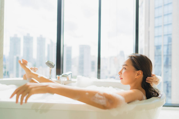 Porträt schöne junge asiatische Frau entspannen und Freizeit in Badewanne Dekoration im Badezimmer Interieur - Foto, Bild
