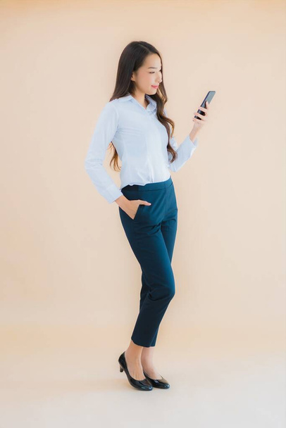 Portrait belle jeune femme asiatique d'affaires avec téléphone portable intelligent et tasse de café - Photo, image