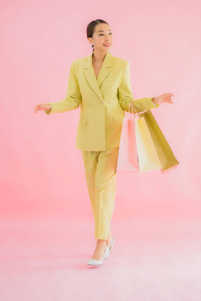 Portrait beautiful young asian business woman with shopping bag on color isolated background - Zdjęcie, obraz