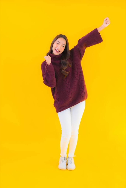 Portrait beautiful young asian woman smile happy in other action on yellow isolated background - Fotó, kép