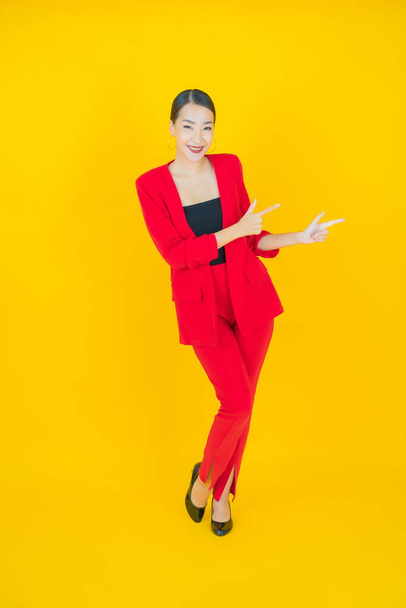 Portret mooie jonge aziatische vrouw glimlach met actie op kleur achtergrond - Foto, afbeelding
