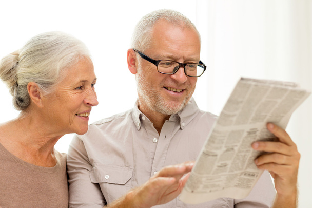 happy senior couple reading newspaper at home - Foto, Imagen