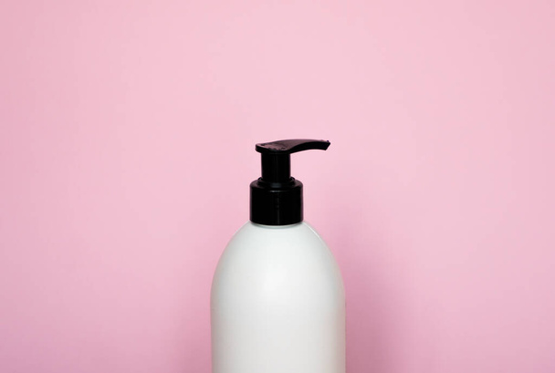 Liquid container for gel, lotion, cream, shampoo, bath foam on pink background. Cosmetic plastic bottle with white dispenser pump. Mock up template for design - Photo, Image