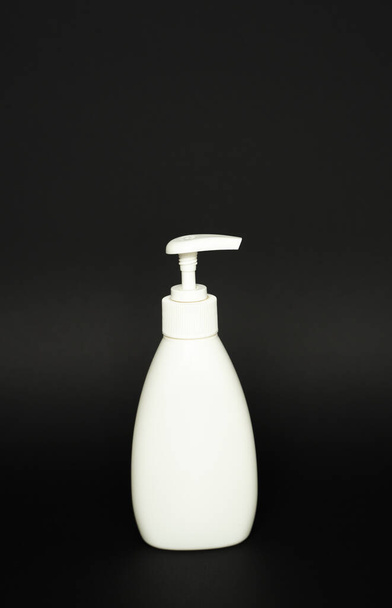 White plastic bottle used for shampoo or soap on black background.. Mock up template for design - Foto, immagini