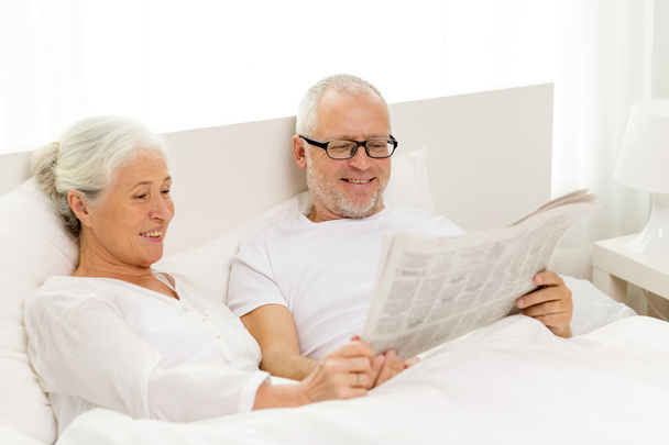 ευτυχισμένο ζευγάρι ανώτερος με εφημερίδα στο κρεβάτι - Φωτογραφία, εικόνα