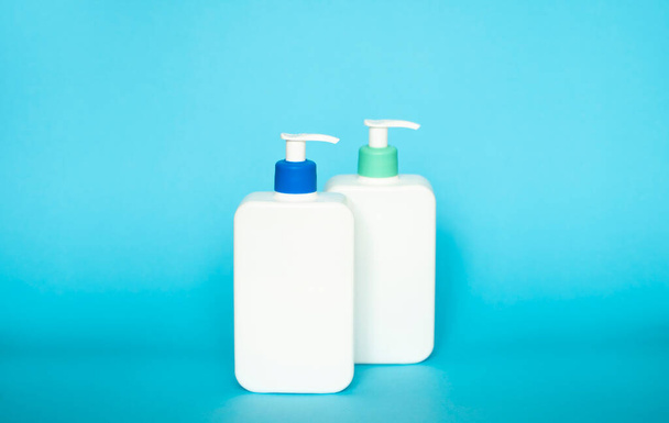 Shampoo or hair conditioner bottles with dispenser pump on blue background - Fotó, kép
