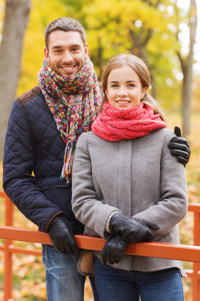 smiling couple hugging on bridge in autumn park - Fotó, kép