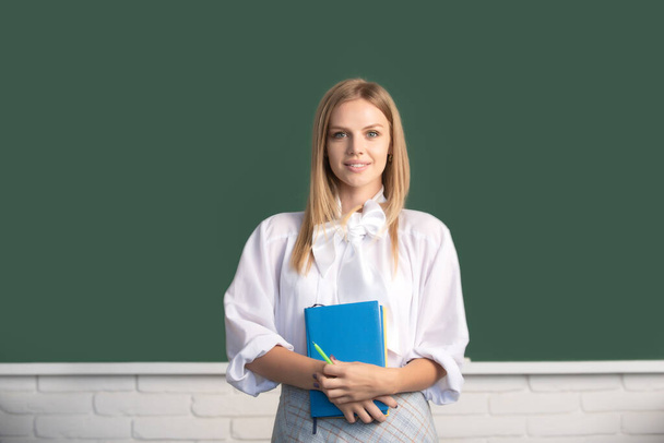 High school student holding book near blackboard, learning english or mathematics in class - Foto, immagini