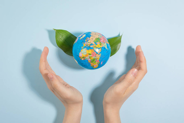 protect earth and environment concept, hand wrapping globe and leaves - Photo, image