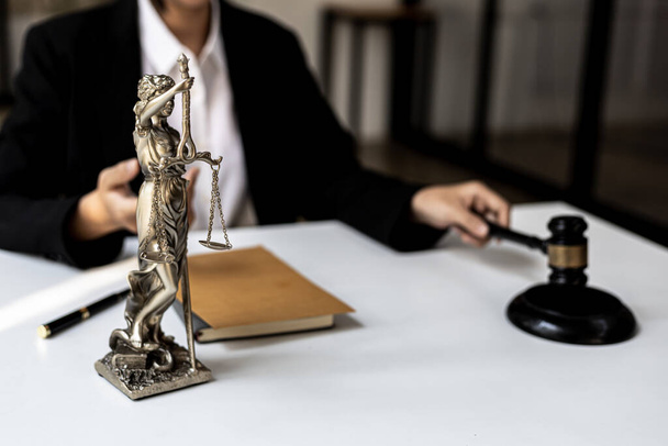 Asianajajan työpöytä Pöydällä on Themis-patsas, joka on oikeudenmukaisuuden jumalatar ja oikeudenmukaisuuden vasara, lakimiehet ylistävät häntä usein oikeudenmukaisuuden symbolina. Lain ja oikeuden käsite. - Valokuva, kuva