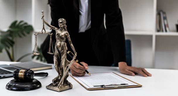 Γραφείο δικηγόρου Στο τραπέζι βρίσκεται ένα άγαλμα του Θέμη που είναι η θεά της δικαιοσύνης και το σφυρί της δικαιοσύνης, οι δικηγόροι συχνά την επαινούν ως σύμβολο της δικαιοσύνης. Έννοια του δικαίου και της δικαιοσύνης. - Φωτογραφία, εικόνα