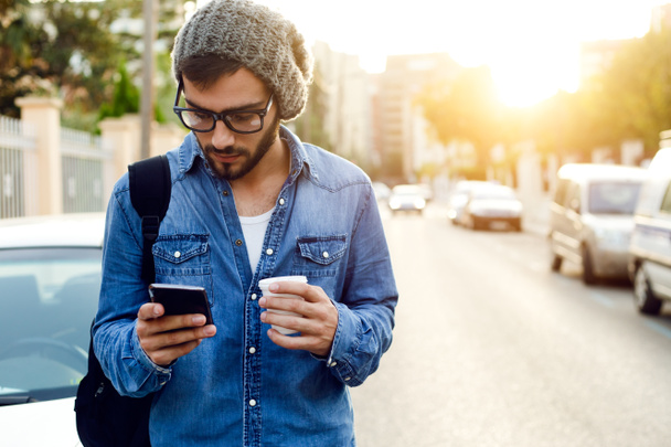 Moderner junger Mann mit Handy auf der Straße. - Foto, Bild