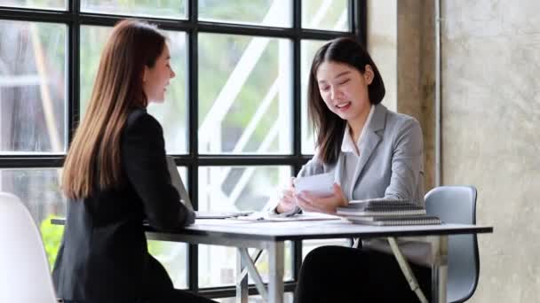 美しいアジアの女性2人が会社の会議室で集まり、成長と事業計画に従うためのビジネスを開発する計画について話し合うために会議を開いています。経営会議のアイデア. - 映像、動画