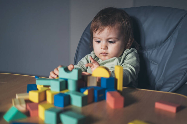 Baby girl torre di costruzione da blocchi colorati seduti a casa. Giocattolo educativo per bambini piccoli. Costruzione gioco creativo. - Foto, immagini