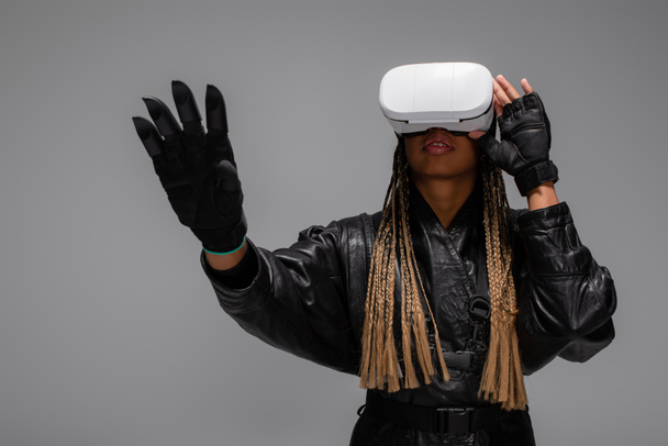African american woman in gloves and vr headset isolated on grey  - Fotó, kép
