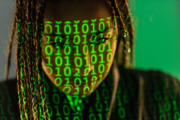 Африканская американка с проекцией двоичного кода на сером фоне  - Фото, изображение