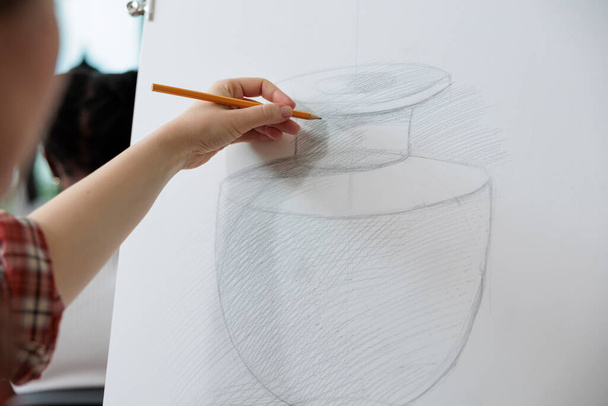 Kreatív diák rajz váza modell vászon dolgozik grafikai illusztráció segítségével vázlatkészítés technika a művészeti iskolában. Férfi festő részt vesz a kreativitás leckét a személyes növekedés - Fotó, kép