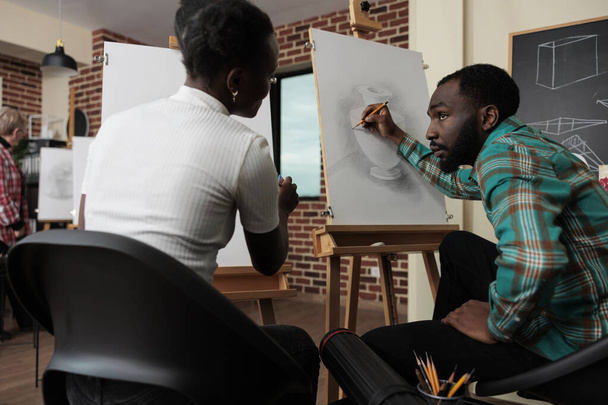 Ressam meslektaşları, yaratıcılık stüdyosunda grafik kalem kullanarak vazo resmi çiziyorlar. Sanat sınıfına katılan çeşitli takımlar kişisel gelişim için yeni sanatsal beceriler geliştiriyor. - Fotoğraf, Görsel