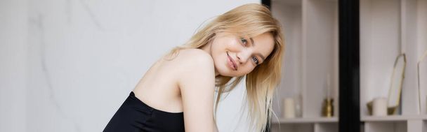 Blonde woman smiling at camera at home, banner  - 写真・画像