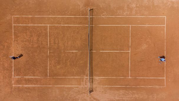 View from above, aerial top view of two people playing tennis on a clay court - Fotografie, Obrázek