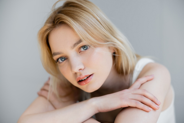 Portrait of young blonde woman looking at camera isolated on grey  - Photo, Image
