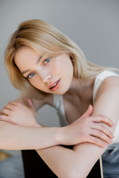Pretty blonde woman looking at camera at home  - Foto, immagini