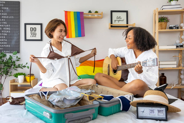 Diversity LGBTQ couple is packing their clothes in luggage for summer trip vacation for homosexual, lesbian and equality for same sex marriage - Foto, afbeelding