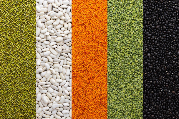 Diferentes tipos de legumbres, lentejas y frijoles mungo, guisantes verdes y frijoles blancos y negros, vista superior - Foto, imagen