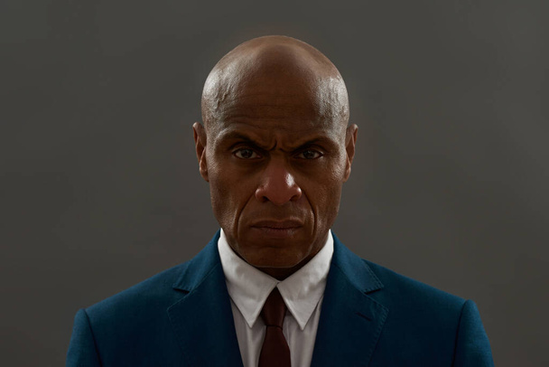 Portrait of confident african american businessman looking at camera. Bald adult man wear suit. Concept of modern successful male lifestyle. Isolated on grey background. Studio shoot. Copy space - Photo, image