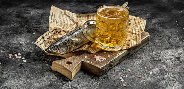 Glass beer with dried fish on wooden background. Beer brewery concept. Snack for beer dried smelts. Beer background. Long banner format. - Фото, изображение