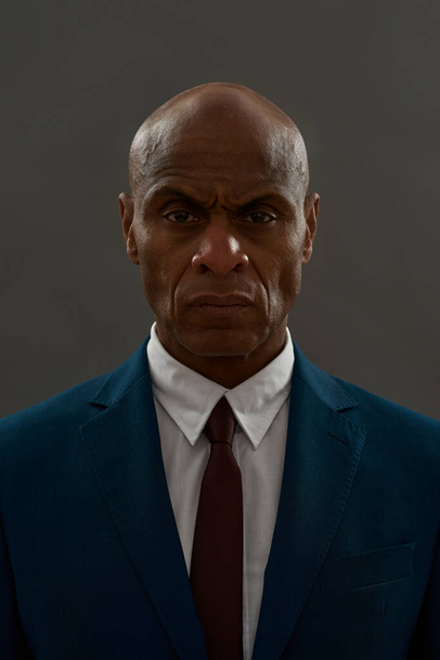 Partial of serious african american businessman looking at camera. Bald adult man wearing suit. Concept of modern successful male lifestyle. Isolated on grey background. Studio shoot. Copy space - Photo, image