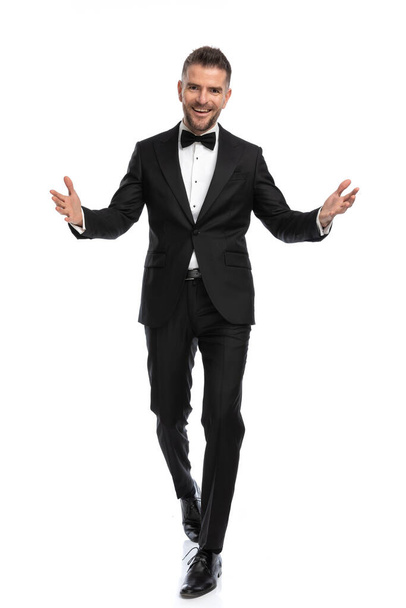 happy businessman greeting us with his arms wide open and a smile on his face against white background - Foto, imagen