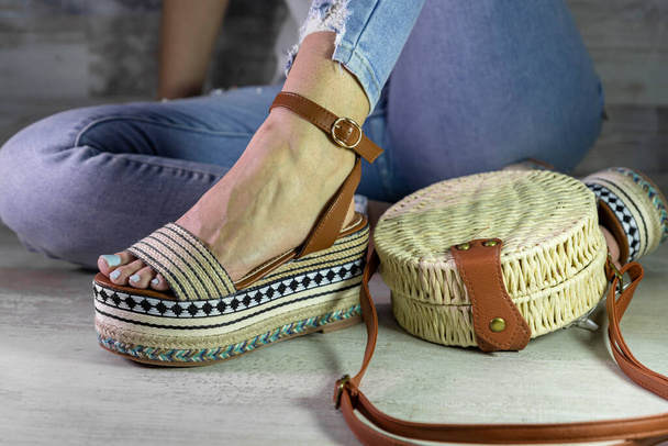 Sexy woman posing in Stylish summer foot ware and purse. Comfortable sandals. Beauty fashion. - Foto, Imagen