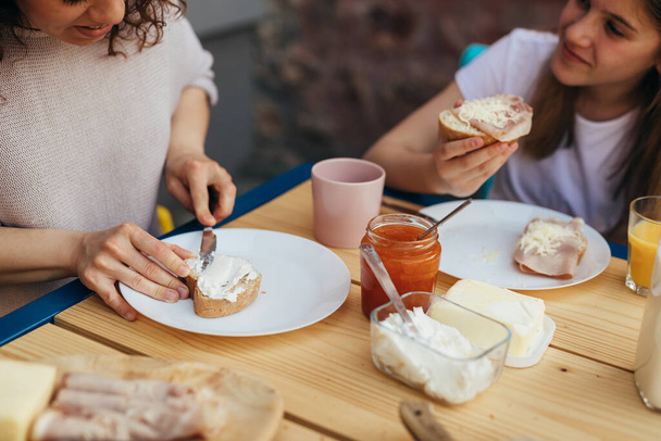 close up of woman spreads butter on bread. breakfast concept - Photo, image