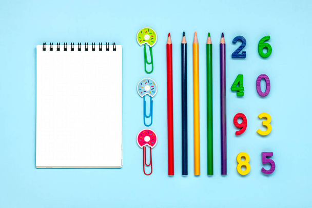 Frame from school and office supplies Paper clips, pens, felt-tip pens, sharpener, notepad, stapler isolated on blue background Flat lay Top view Back to school, education concept Mock up Copy space. - Фото, изображение