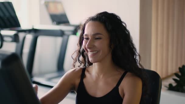 Posilovací cvičení. Detail portrét mladé šťastné sportovní dáma zapínání na tréninkový přístroj a začít cvičit v moderní tělocvičně, zpomalení - Záběry, video
