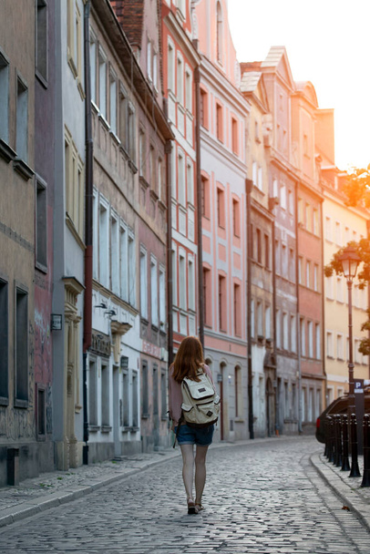 a girl walks through the streets of an old European cit - Фото, изображение