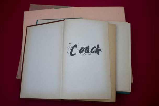 ヴィンテージ、ナチュラルパターンの古いアンティーク紙のデザインで開かれた本の中でコーチの言葉. - 写真・画像