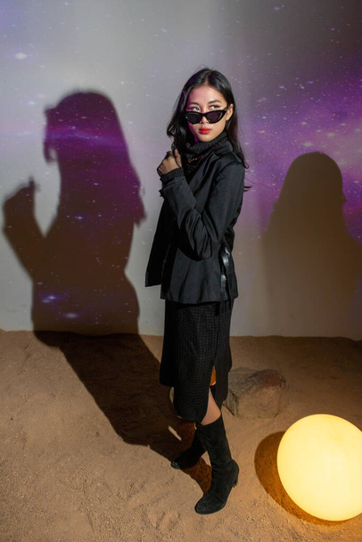 Concept à la mode, Mode femme porter robe noire avec des lunettes de soleil à poser sur fond d'espace. - Photo, image