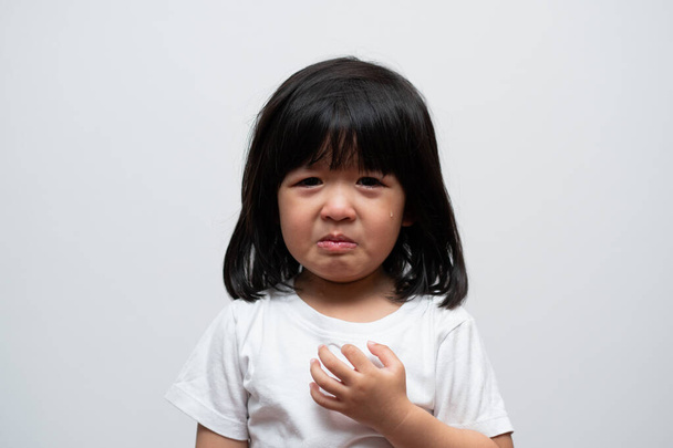 Ritratto di asiatica arrabbiata, triste e piangere bambina su sfondo bianco isolato, L'emozione di un bambino quando capriccio e pazzo, espressione emozione scontrosa. Kid concetto di controllo emotivo - Foto, immagini