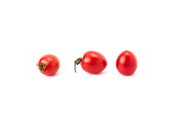 Tre pomodorini rossi su fondo bianco. Cibo vegetariano. Cibo ecologico - Foto, immagini