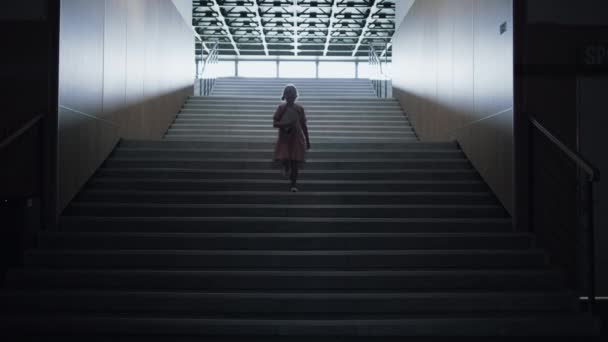 Una niña bajando las escaleras de la escuela entra en el pasillo vacío. Colegiala solitaria ensangrentada sosteniendo libros caminando sola corredor oscuro. Asustado niño de edad elemental pasando aula cerrada después de clases. - Imágenes, Vídeo