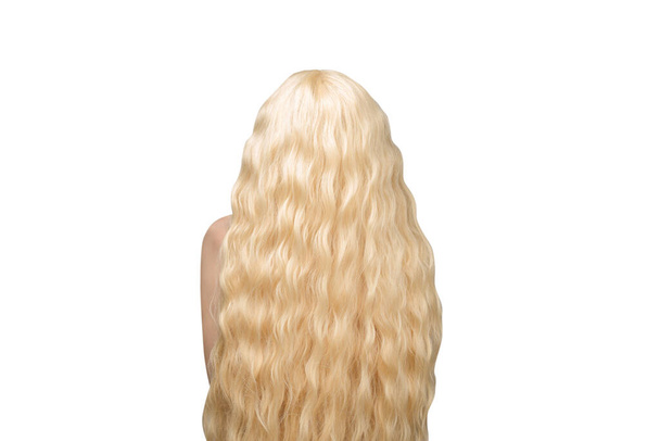 Uzun sarı ve kıvırcık saçlı bir kadın. Kadın tecrit edilmiş.  - Fotoğraf, Görsel